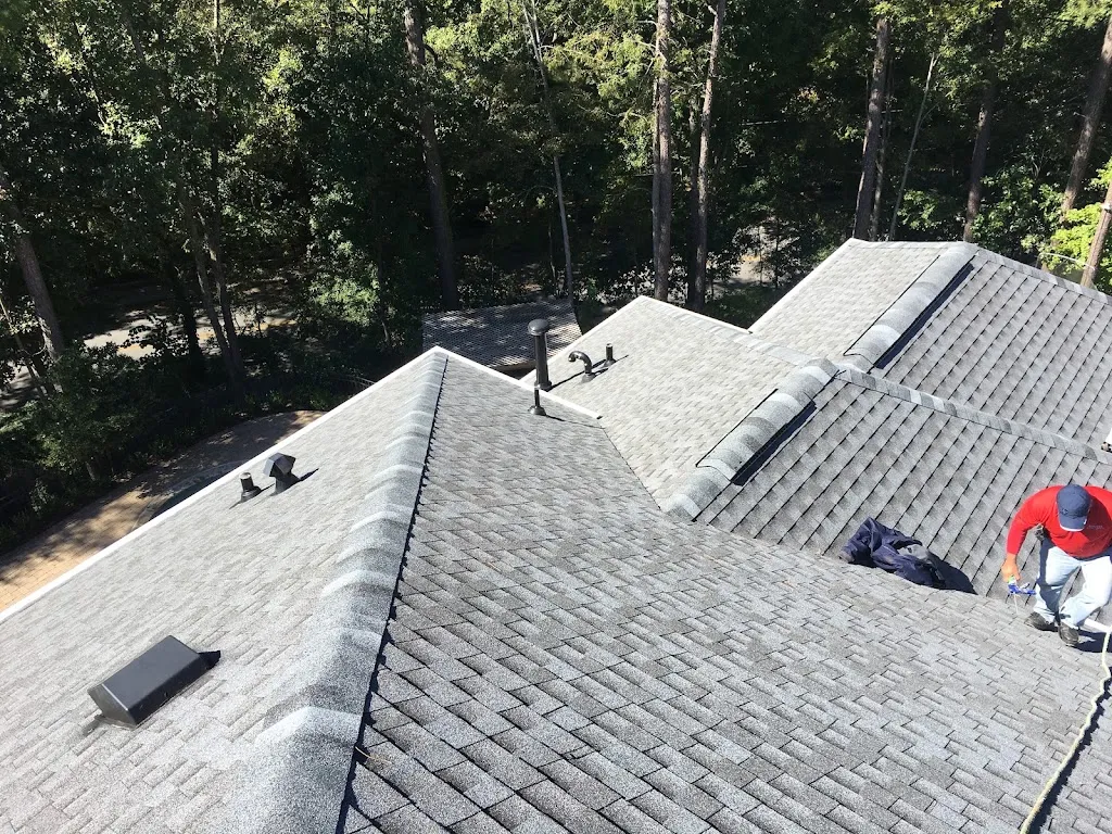 Hill Top Roofing crew member on a newly installed architectural shingle roof